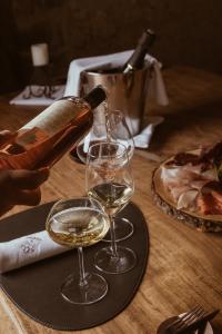 Vin blanc versé dans des verres en cristal lors d’une dégustation, accompagné de charcuteries, dans une atmosphère élégante et raffinée.