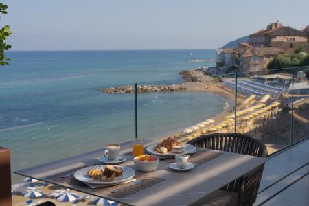 Breakfast on a sea-view terrace, with coffee, croissants, and pastries.
