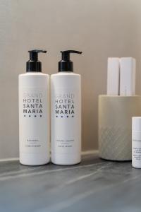 Grand Hotel Santa Maria bathroom dispensers containing conditioner and liquid soap, toiletries, and body care products in an elegant hotel setting.