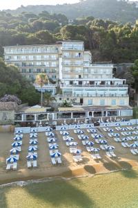 Seafront hotel with a private beach equipped with parasols and sun loungers.