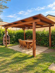 Jardin privé avec pergola en bois, table et chaises d’extérieur, barbecue maçonné et haie verte.